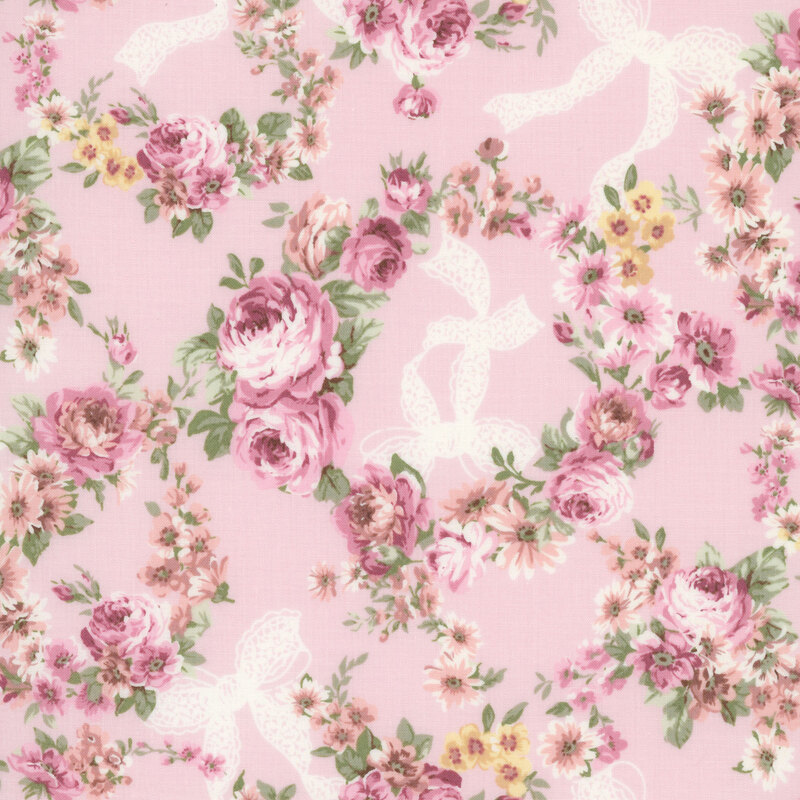 Soft pink fabric with wreaths of florals, cream colored bows, and purple-pink roses.