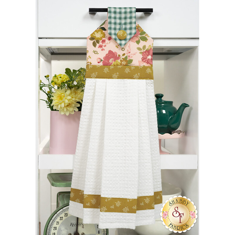 The completed Hanging Towel Kit colored in pink fabrics from the Renew collection from Riley Blake Designs, hung on a drawer surrounded by coordinating patriotic décor. 