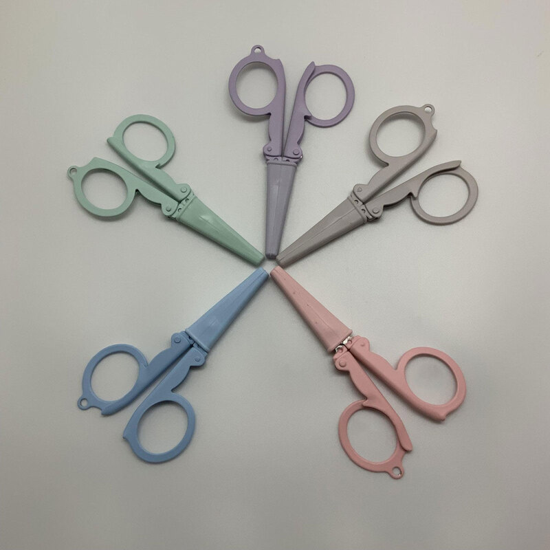 Six pairs of colorful scissors arranged in a circular pattern on a light gray background.