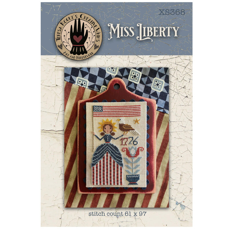 Miss Liberty pattern cover featuring a the finished cross-stitch staged with americana decor.