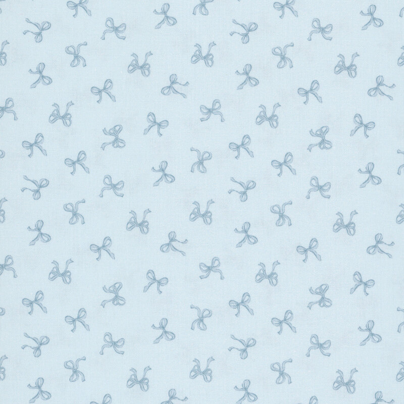 Small blue bows tossed onto a baby blue fabric.
