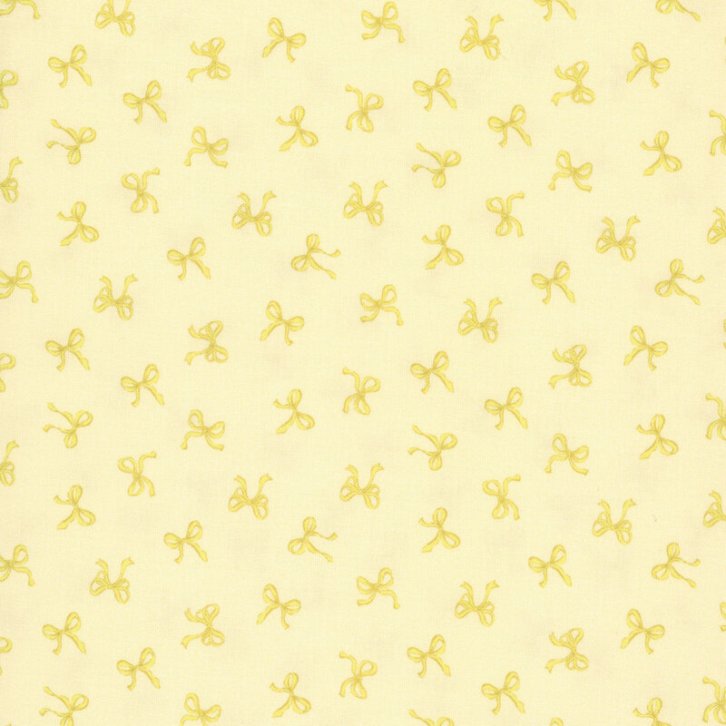 Small yellow bows tossed onto a pastel yellow fabric.