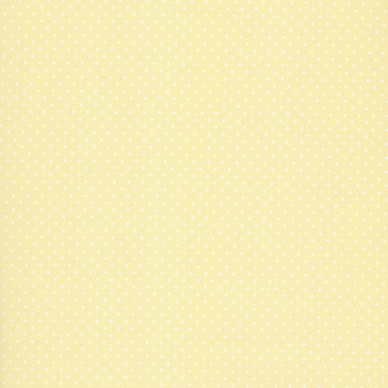Soft light yellow polka dots on a pastel yellow fabric.