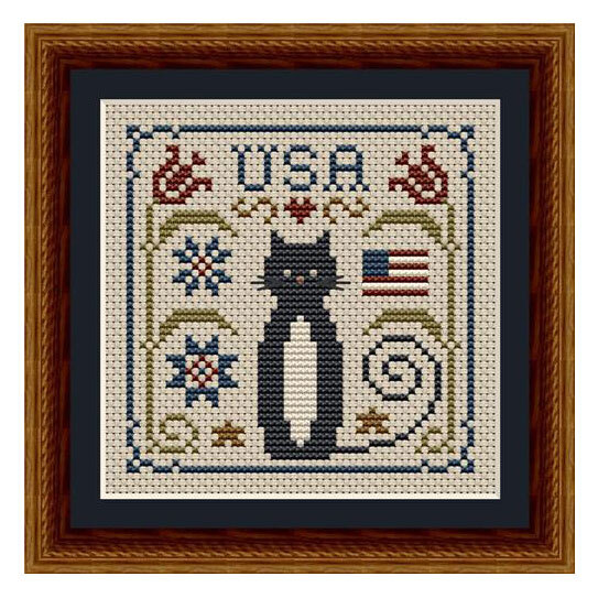 Finished and framed cross stitch project featuring a black cat, sawtooth stars, a flag, and florals.