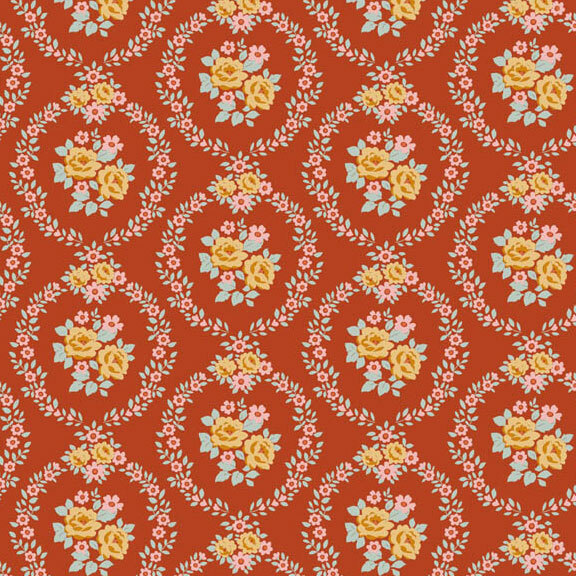 This rust orange fabric features pink and ocher floral wreaths framing centerpieces. 