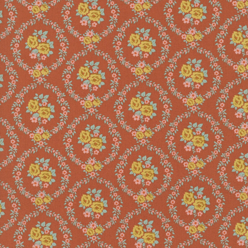 This rust orange fabric features pink and ocher floral wreaths framing centerpieces. 