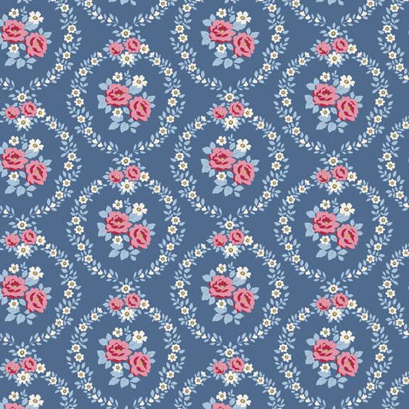 This blue fabric features pink and white floral wreaths framing centerpieces. 