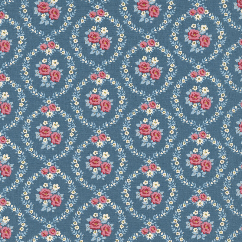 This blue fabric features pink and white floral wreaths framing centerpieces. 