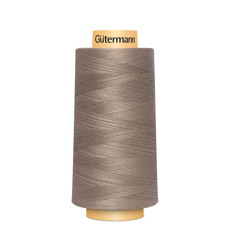 A spool of Gütermann Cotton Thread - Taupe thread on a white background