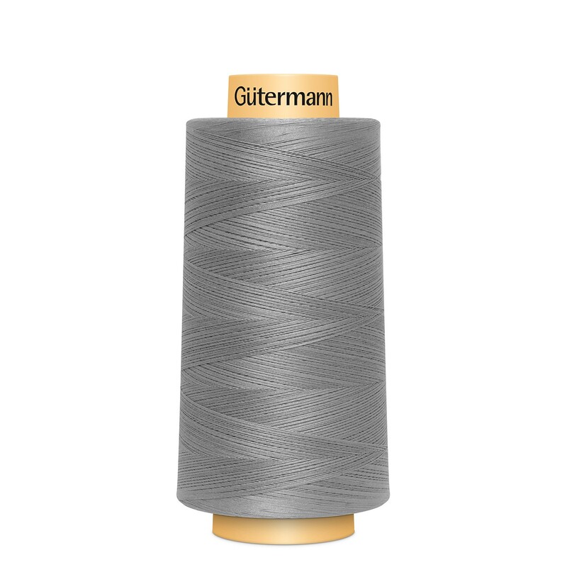A spool of Gütermann Cotton Thread - Gray thread on a white background