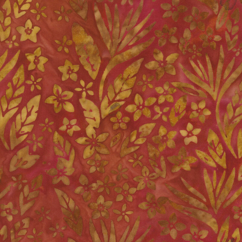 Gold leaves and florals over a rusty red batik.