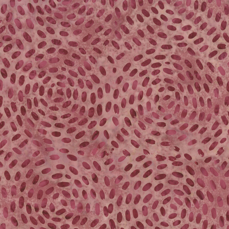mottled dusty rose fabric with a circular pattern of scattered dots in tonal hues