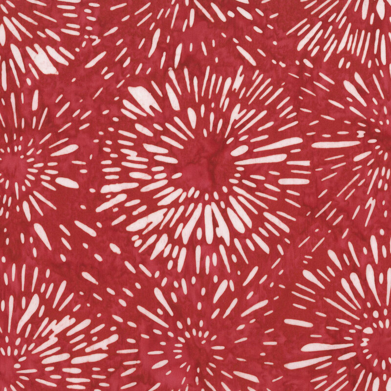 Red fabric layered with cream stylized firework bursts.