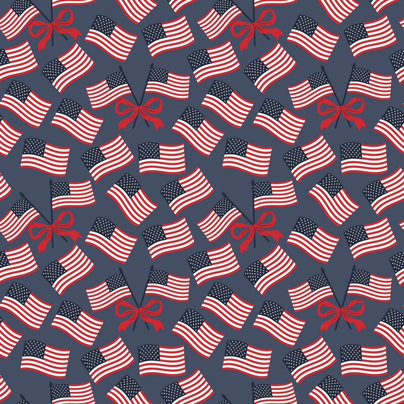 Denim blue fabric with tossed American flags and red bows.