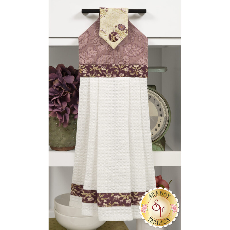 A head on shot of the completed plum Hanging Towel, colored in fabrics from the Forest Glen collection by Andover Fabrics, hung on kitchen drawer and staged with coordinating décor.