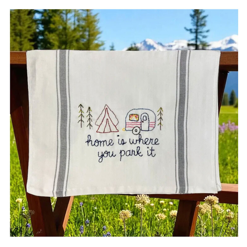 A decorative kitchen towel featuring a campsite.