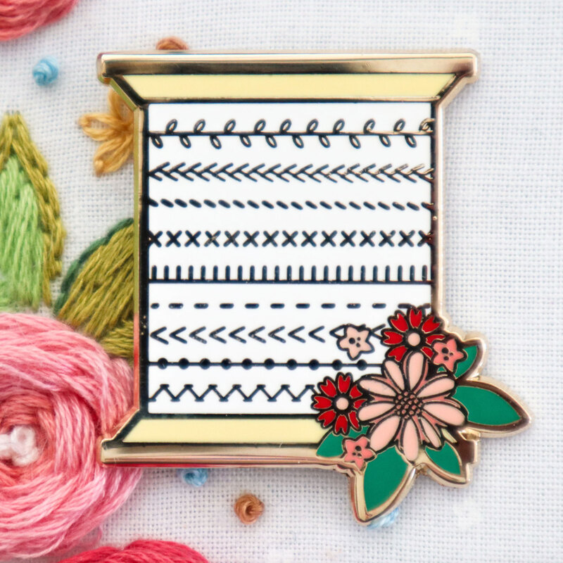 The stitchy spool needle miner displayed on a hand embroidery project.