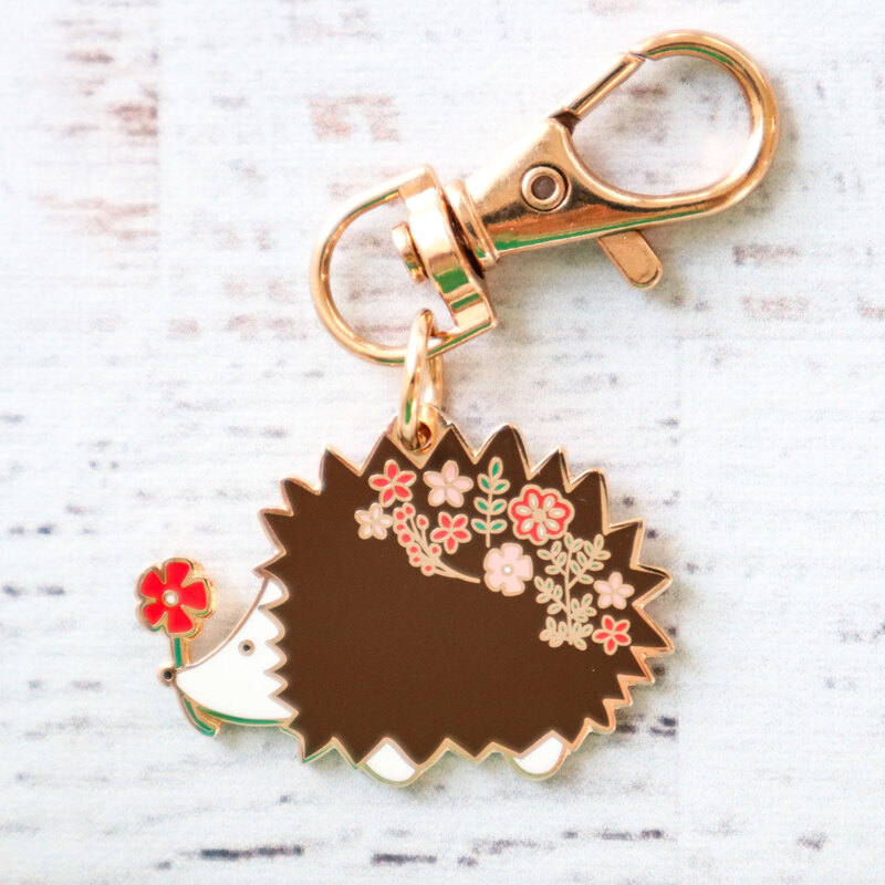 Gold keychain charm shaped like a hedgehog. 