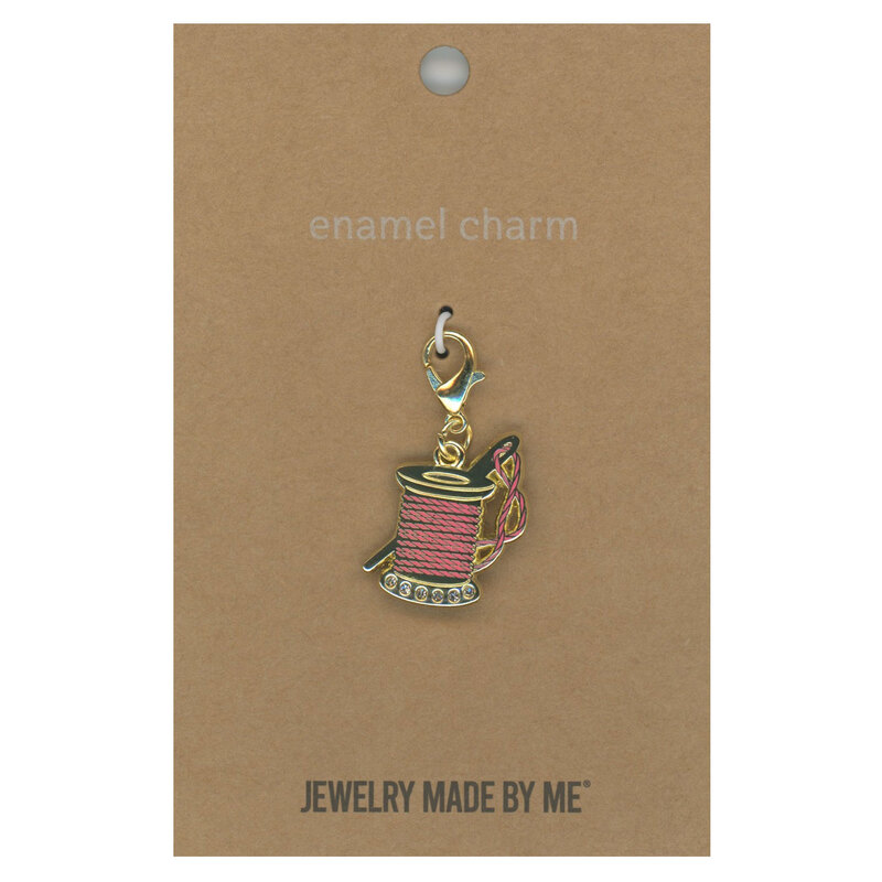 Enamel charm featuring the design of a spool of thread, isolated on a white background.