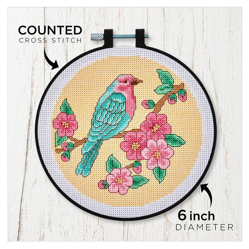 Counted cross stitch kit packaging featuring colorful a bird with cherry blossoms in a circular design. 