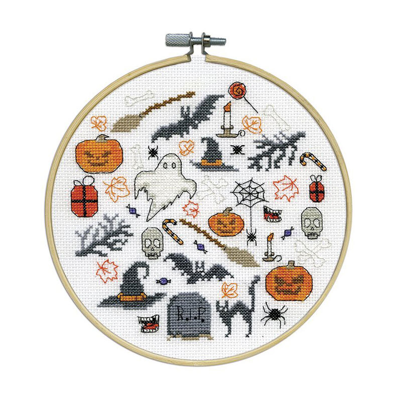 The completed cross stitch kit featuring halloween themed motifs, framed in a wooden embroidery hoop.