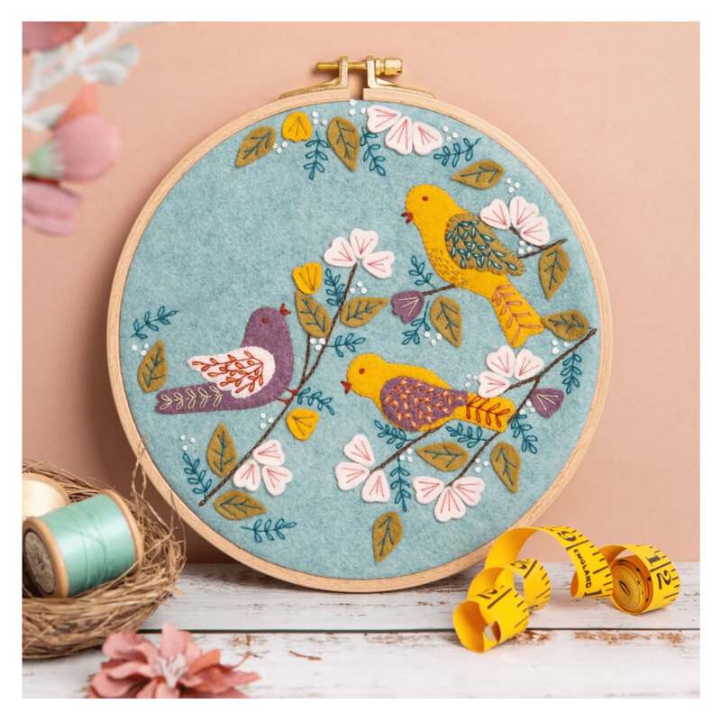 The completed Dawn Chorus Wool Mix Appliqué Kit in its hoop and surrounded by coordinating décor. 