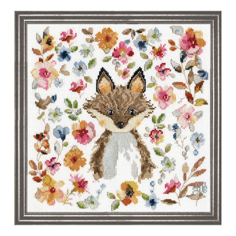 A framed and completed cross stitch project featuring a watercolor fox surrounded by colorful floral blooms and leaves.