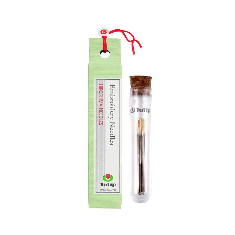 Assorted set of tulip embroidery needles in a thin container next to a green carton package.