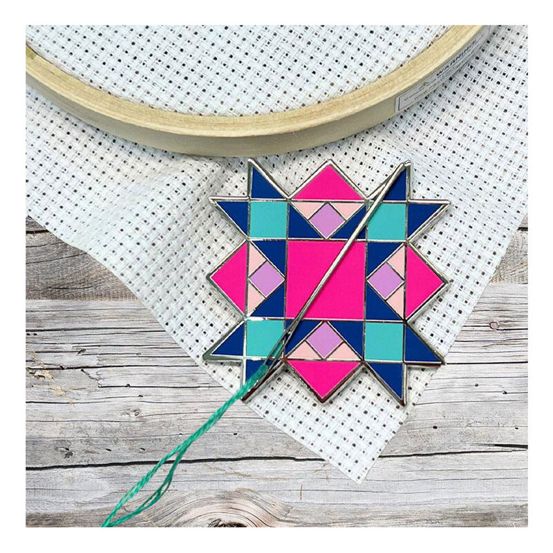 The quilt star needle miner displayed on a hand embroidery project.