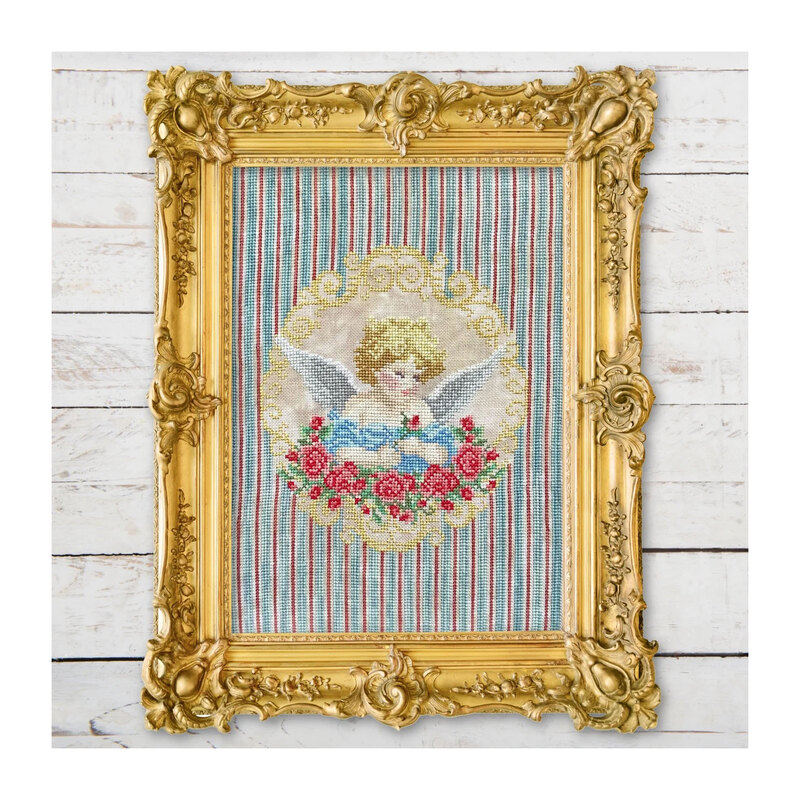 Finished My Angel pattern of an angel inside of an ornamental gold and rose border on a striped fabric framed by an ornate gold frame.