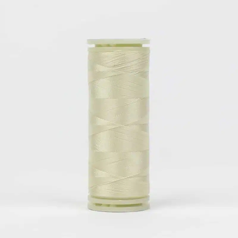 A spool of WonderFil DecoBob DB-112 Antique White thread on a white background.