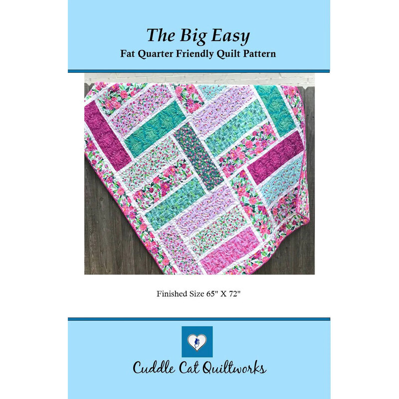 Cover with the finished The Big Easy pattern with purple and teal tone fabrics hung on a wooden fence.