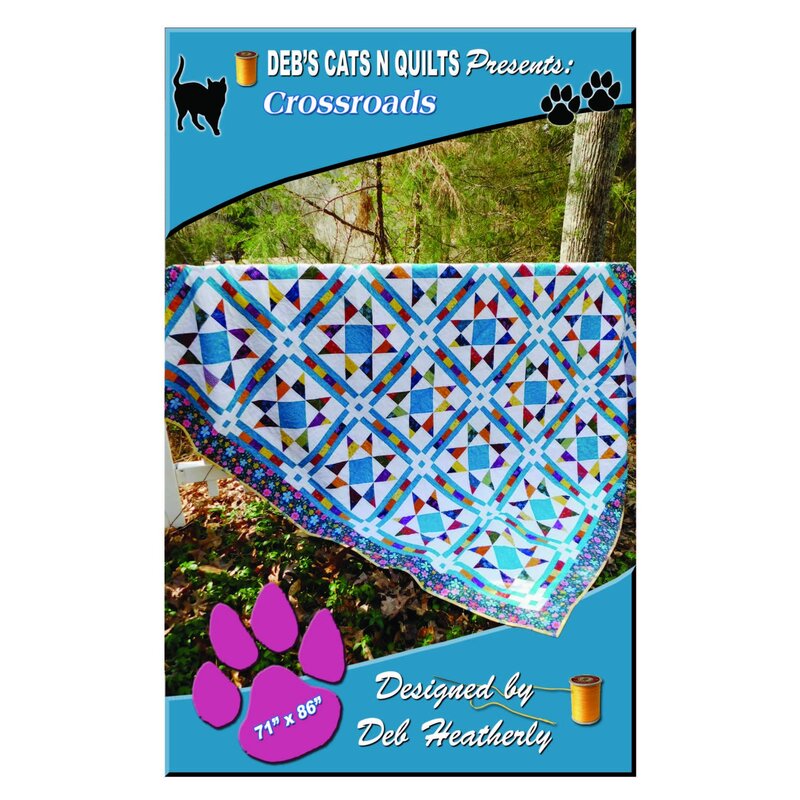 The front of the Crossroads pattern with the completed quilt displayed hanging over a fence.