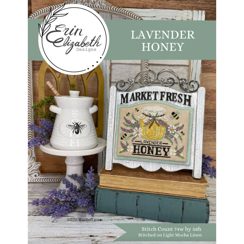A finished and framed lavender honey pattern with coordinating décor and a stitch count in the bottom right corner. 