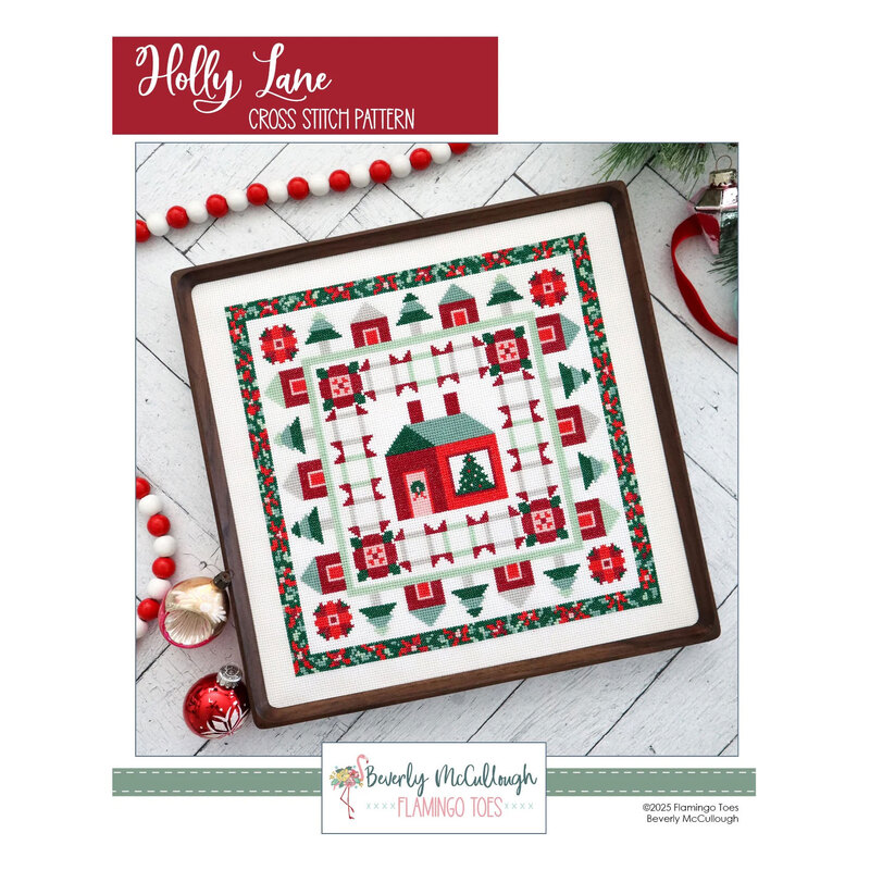 Front cover of the Holly Lane cross stitch pattern of the finished product in a wooden frame on white herringbone planks surrounded by Christmas motifs.