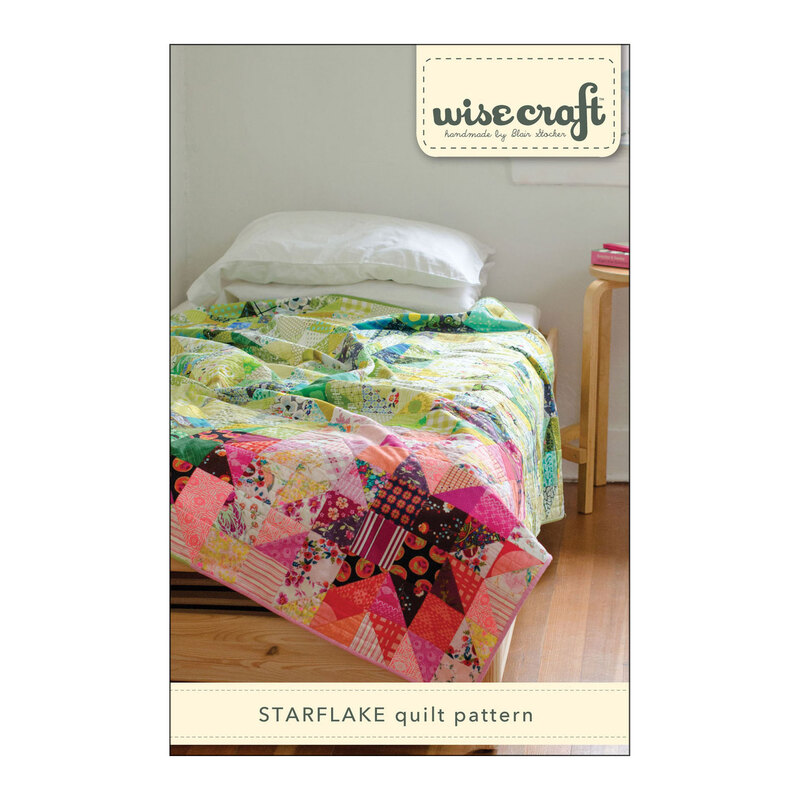 The front of the Starflake Quilt Pattern, showing the finished quilt draped over a bed.
