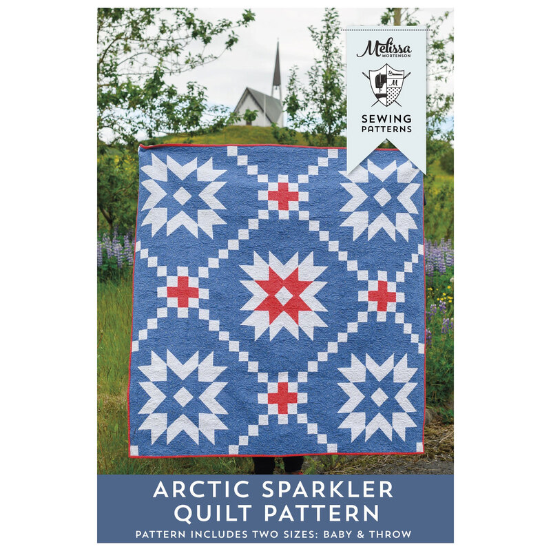 Front cover of the Arctic Sparkler Quilt Pattern featuring the blue, red, and white finished quilt displayed outside.