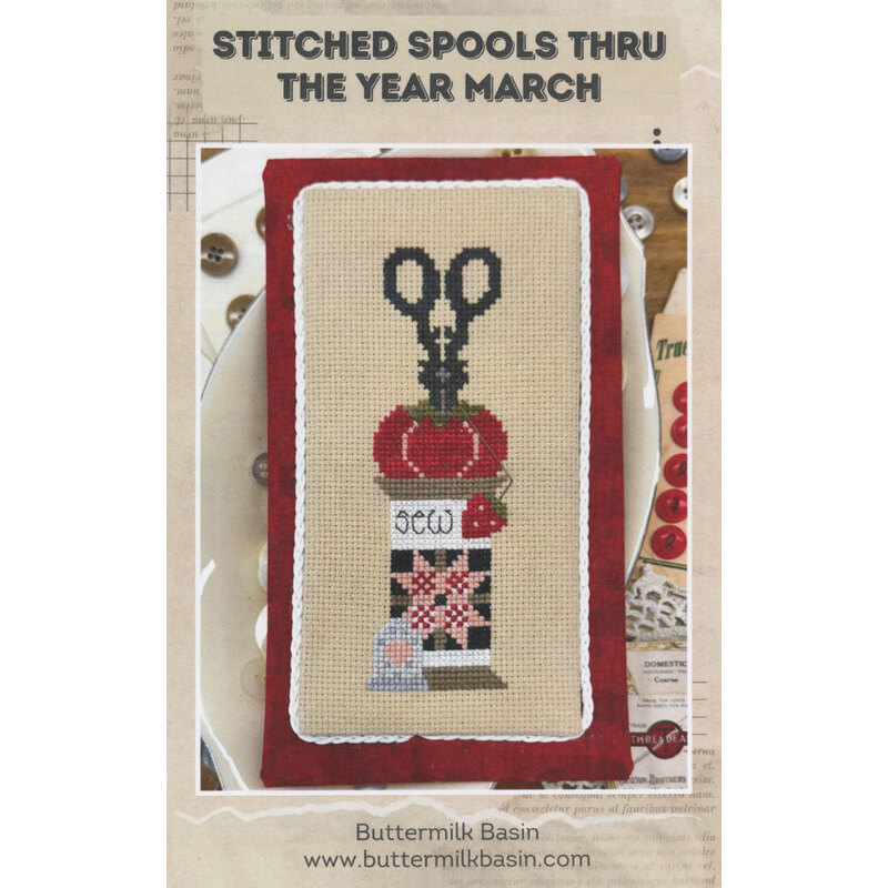 Cross stich pattern with scissors, thread spool on a red border.