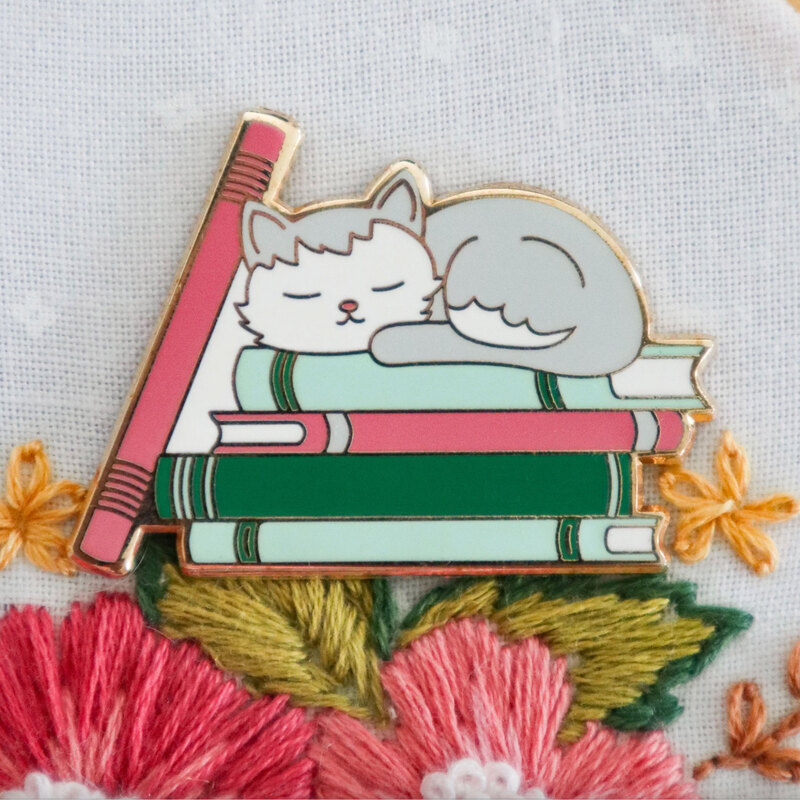The bookish cat needle miner displayed on a hand embroidery project.
