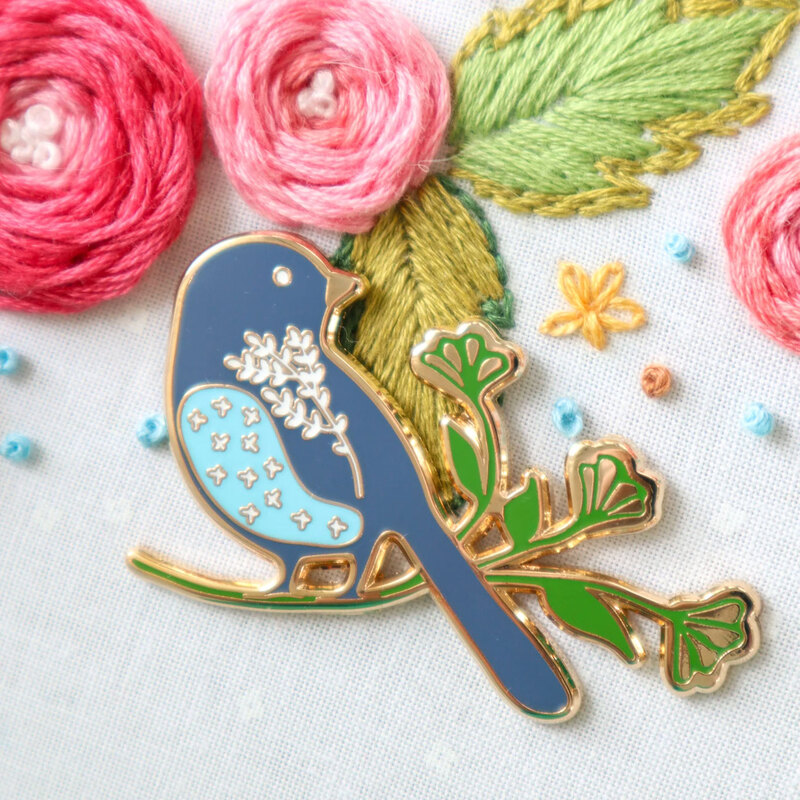 The bird needle miner displayed on a hand embroidery project.