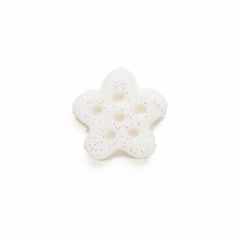 Small white glittery clay snowflake button, isolated on a white background. 