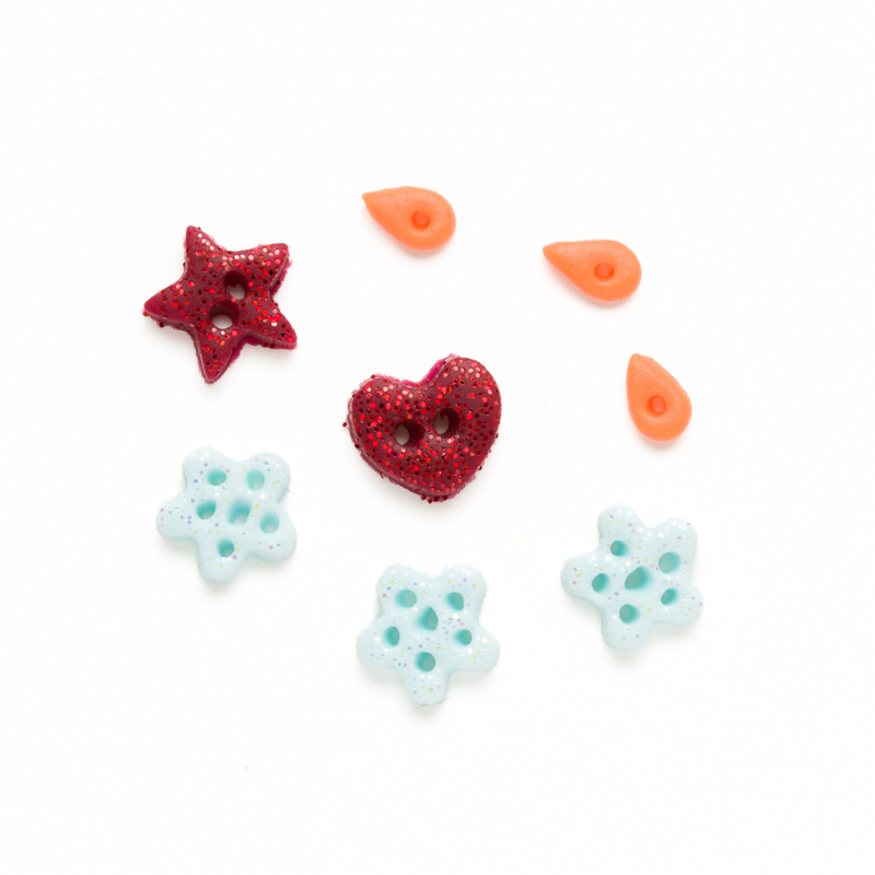 Clay button back of winter themed charms, isolated on a white background. 