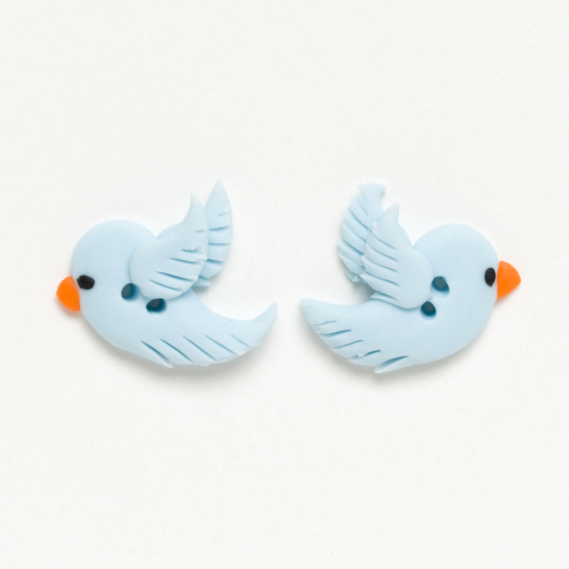 Two blue bird-shaped clay buttons with orange beaks on a white background.