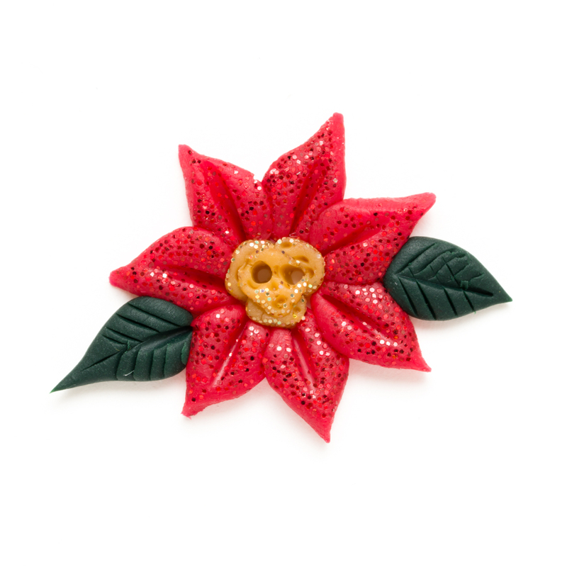 Glittery red poinsettia button on a white background.
