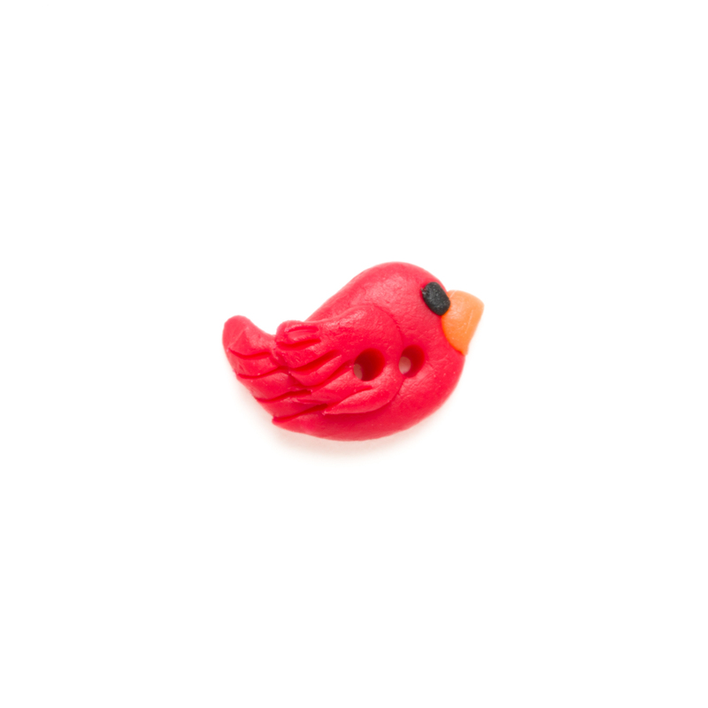 Small red clay cardinal button, isolated on a white background. 