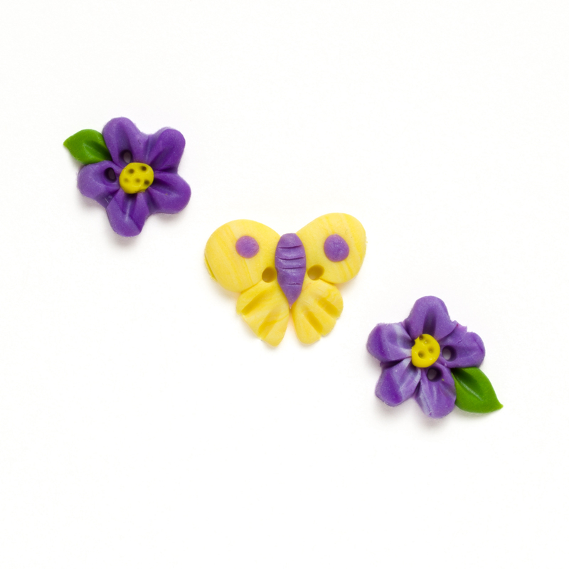 Clay button pack with spring themed charms, isolated on a white background. 