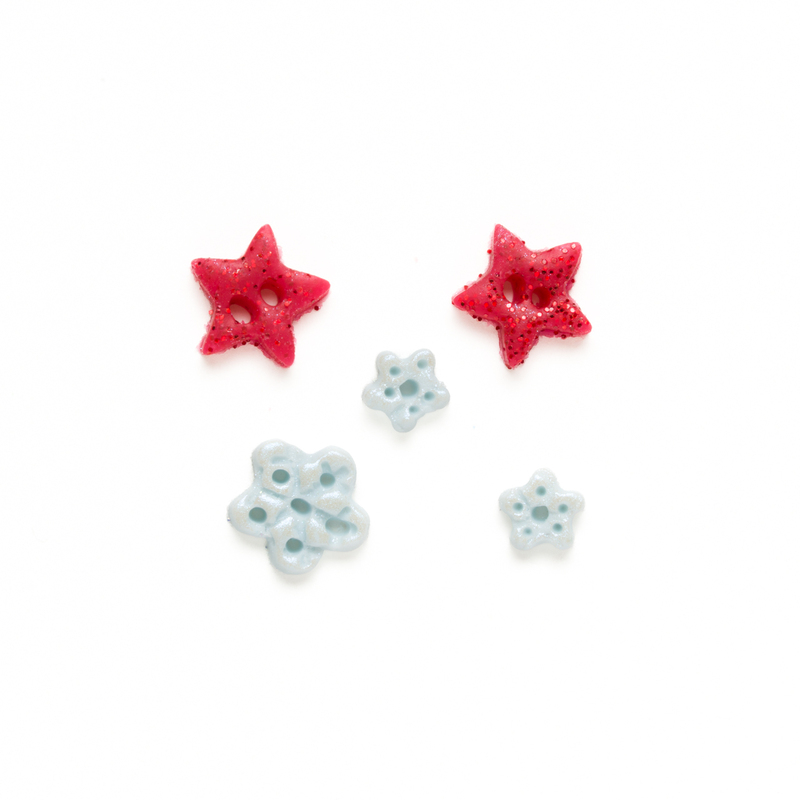 Clay button pack with winter themed charms, isolated on a white background. 