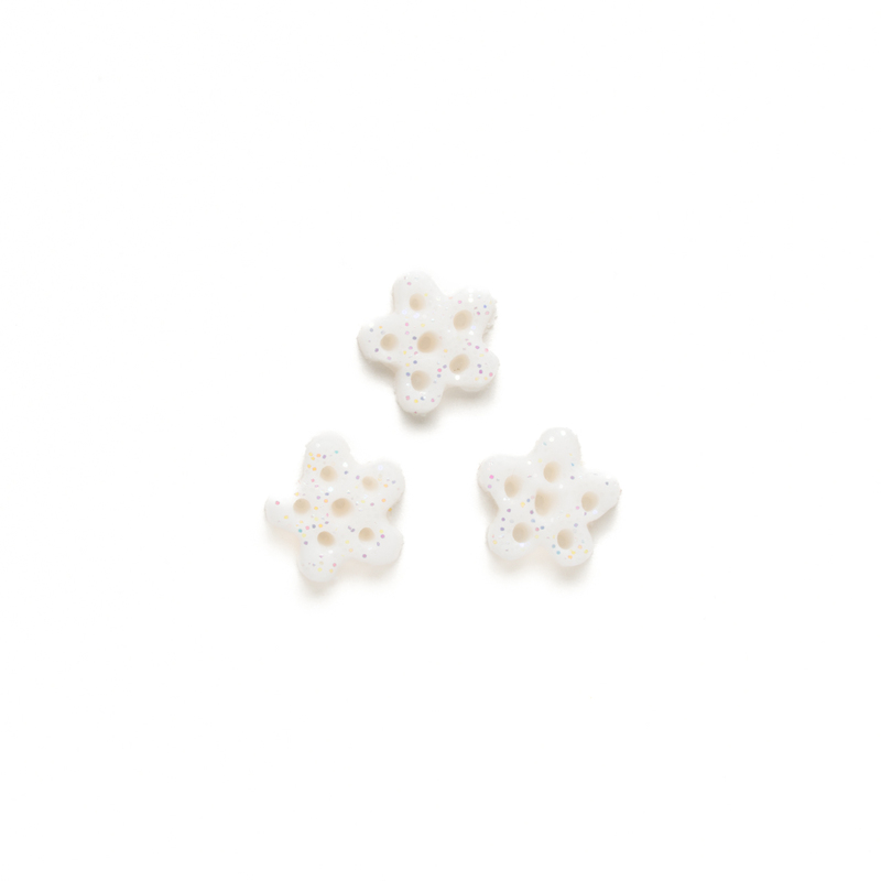 Set of 3 small white glittery clay snowflake buttons, isolated on a white background. 