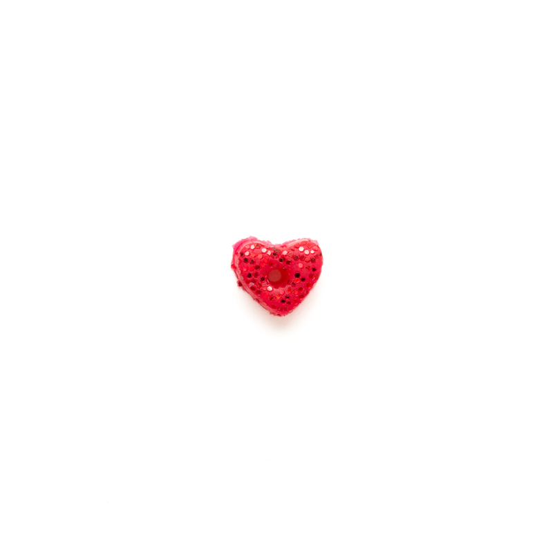 Small red glittery heart clay button, isolated on a white background. 