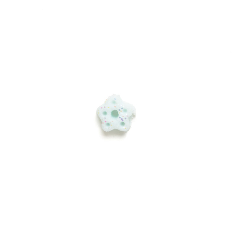 Small bluish white clay snowflake button with speckles of glitter on a white background.